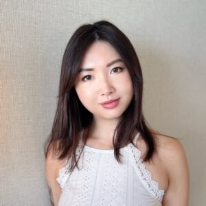 Photo of the author Bei Lin, with dark hair and a white top, smiling.