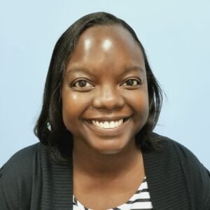 Headshot of a Black woman with chin-length black hair against a light blue background.