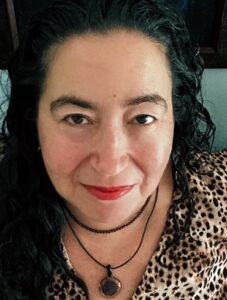 A photo of a woman with long, dark hair wearing a leopard print dress.