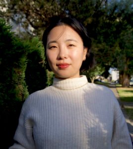 Lynn D. Jung is a Korean woman with jaw-length hair. She wears a white sweater and faces the camera with a slight smile.