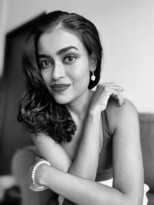 A black and white photo of moniza, a short brown woman with her hair down.