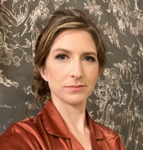 Morgan J. Watchorn, a white woman with blonde hair in a bun, has a slight smile and faces the camera in a portrait taken shoulders-up.