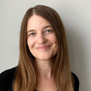 Headshot of Triona Murphy, a smiling white woman with long brown hair wearing a black shirt.